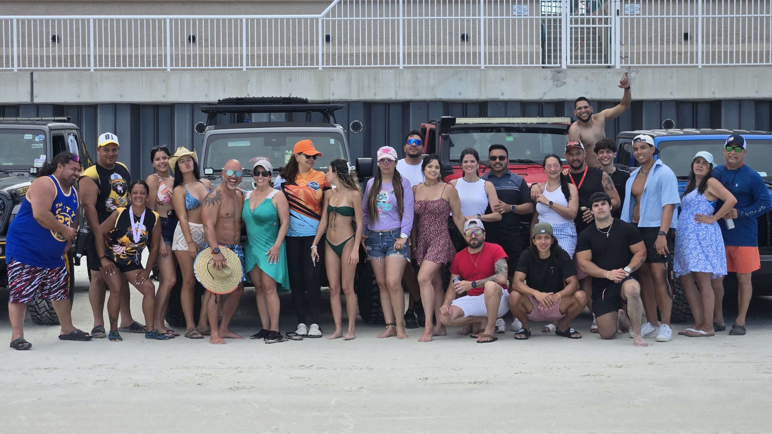 Group of Orlando Jeep Team members smiling and standing in front of Jeeps on a beach.