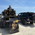 DJ performing from a Jeep with a custom audio system and Mr. Silent branding at a beach event.